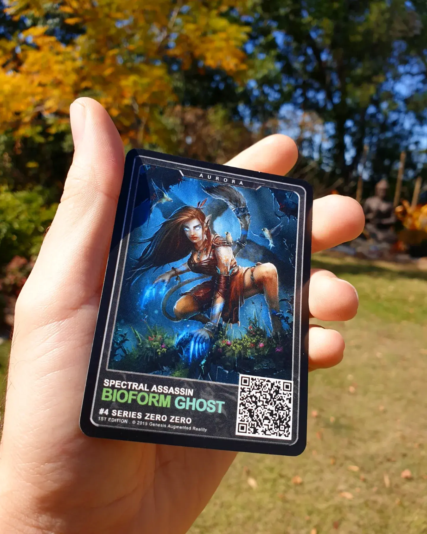 A hand holding the Aurora trading card for the Genesis Augmented Reality Trading Card Game